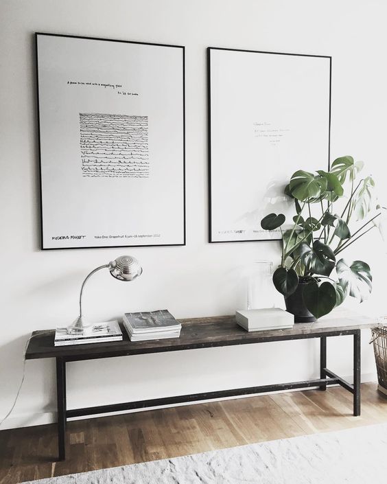 a Scandinavian entryway with a reclaimed wooden bench and a duo of black and white artworks
