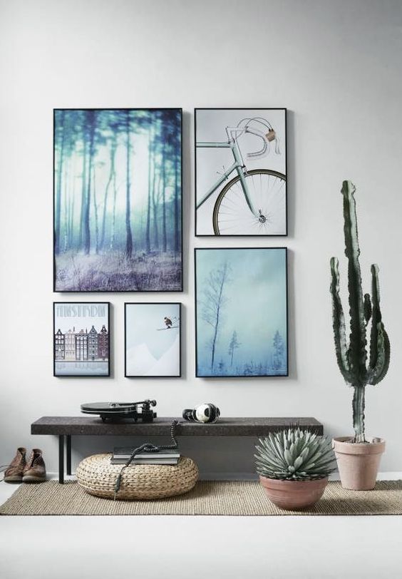 a stone and metal bench, a wicker ottoman, cacti and a gallery wall with matching frames and muted color artworks