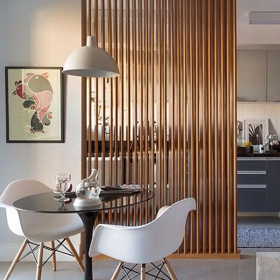 a vertical wooden plank screens gently separates the kitchen and the dining space