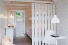 25 a white wooden plank screen gently separates a small shabby chic studio space