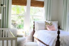 26 a traditional farmhouse bedroom with a crib by the wall and a comfy chair with an ottoman