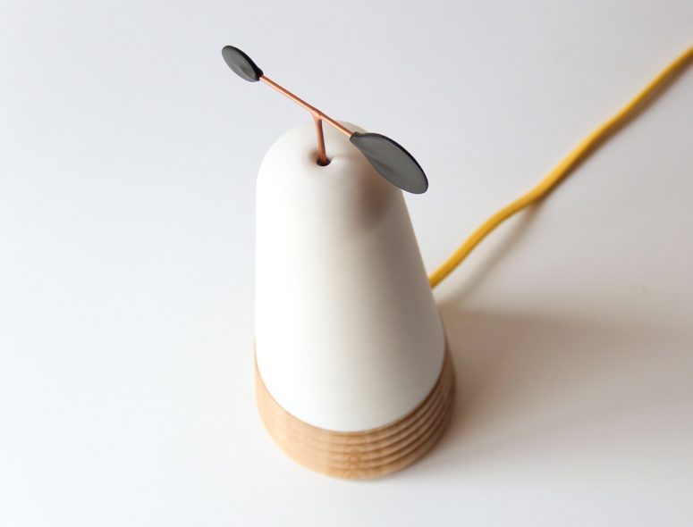 Copper, glass and wood comprise a lamp that looks like a wind turbine