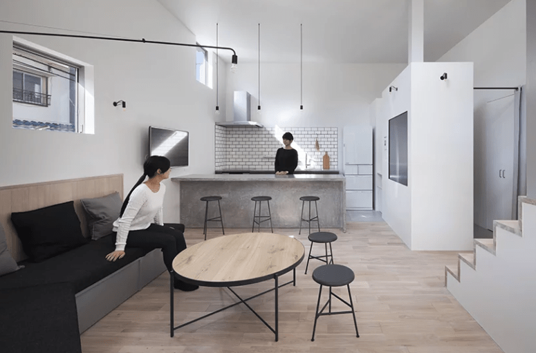 stylish and practical brick backsplash This is the main space with a living room and a kitchen with a brick backsplash and a concrete kitchen island for a more textural look