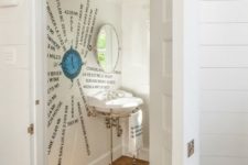 04 a creative sea-inspired powder room with a window, an artwork on the wall and a round mirror