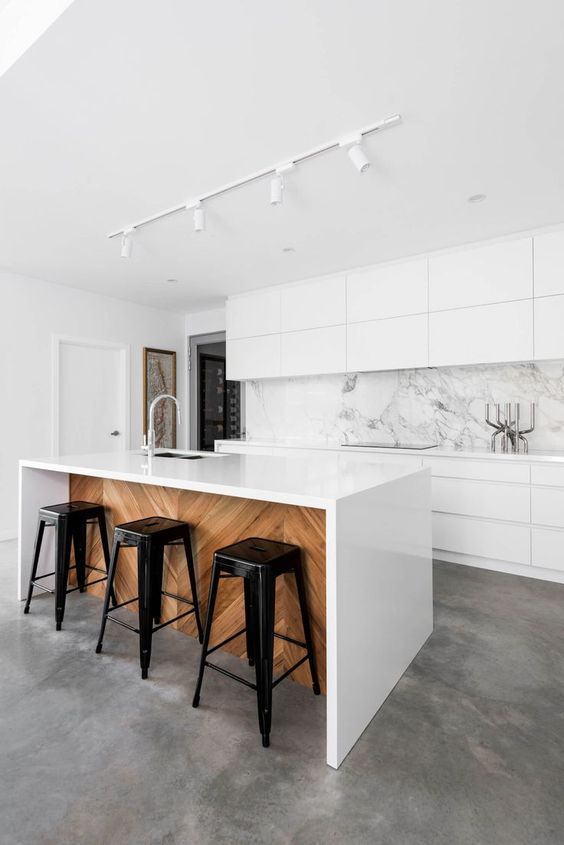 sleek white cabinets and a white marble backsplash that makes the whole space very exquisite and edgy