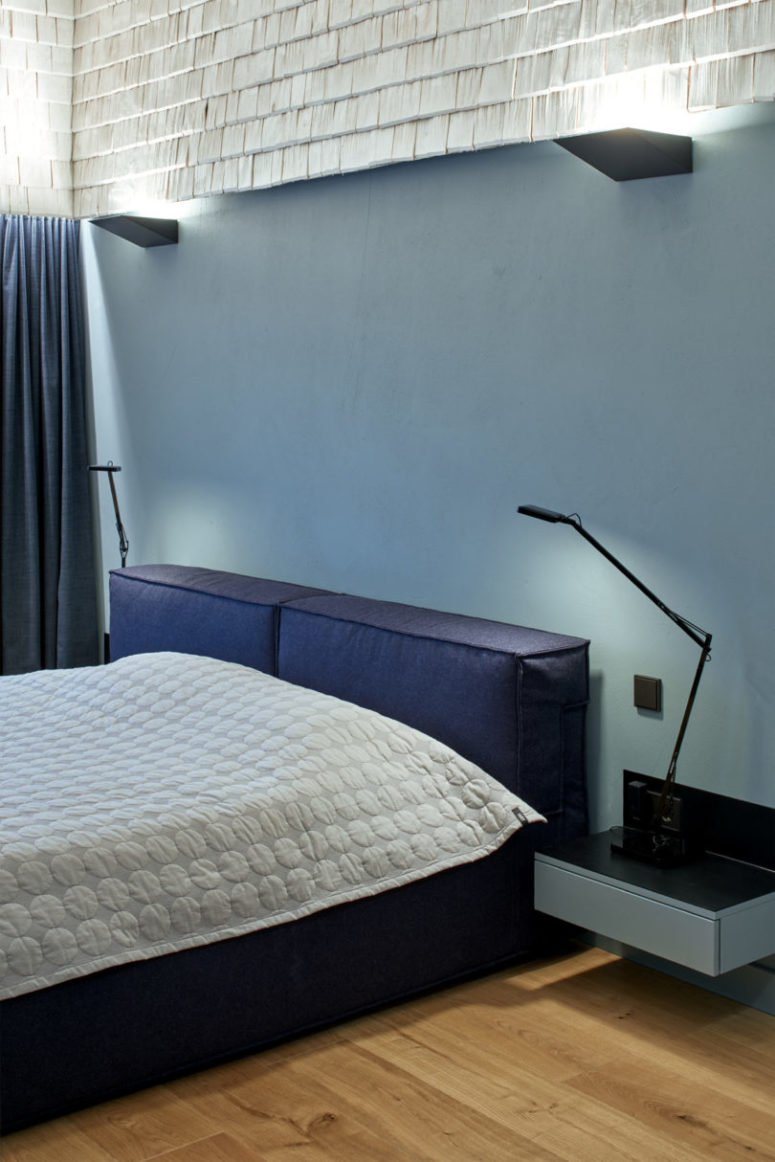 The master bedroom is done with an upholstered bed, floating nightstands, lights built under the wood shingles The master bedroom is done with an upholstered bed, floating nightstands, lights built under the wood shingles