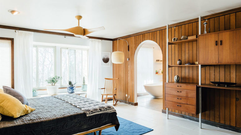 wood accent wall in a bedroom The master bedroom is done with mid-century modern furniture, a wood clad wall with an arched walkway to the bathroom