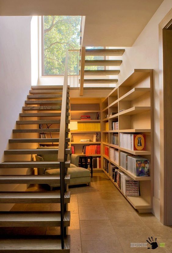 under the stairs reading nook with shelves and a comfy lounge chair and enough light
