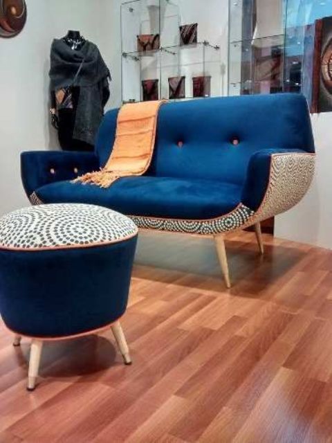 a chic and bold mid-century modern chair with a navy top and a printed base and a matching footrest