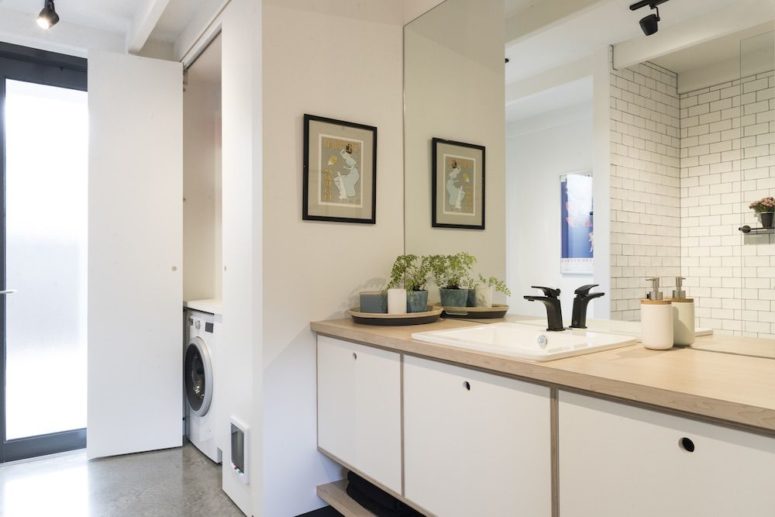 hidden bathroom storage solution The bathroom features a hidden storage space and sleek modern furniture plus light-colored wooden touches
