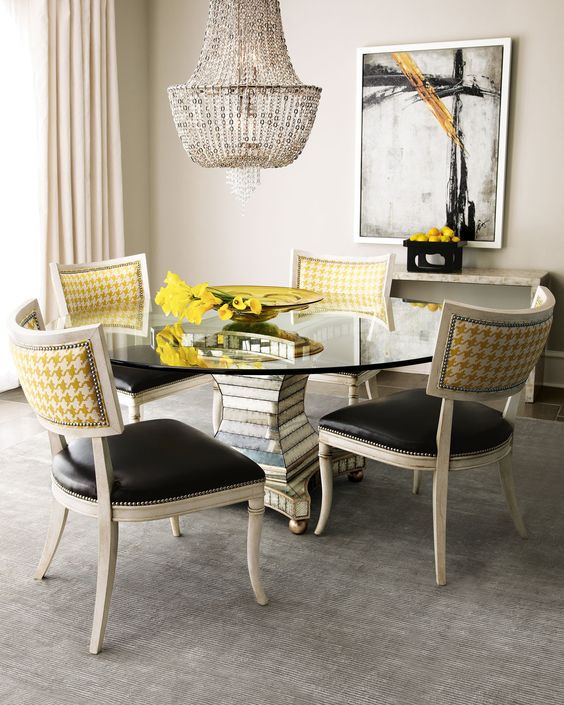 a chic dining space with creative chairs with black leather seats and yellow print backs with a nail trim