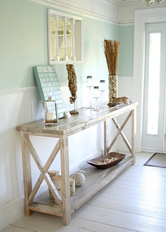 a wooden rustic console, artworks, shells in a bowl, a sea horse of driftwood and lanterns