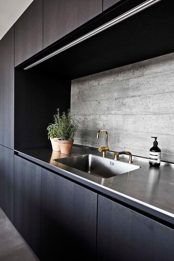 dark wooden cabinets, stained steel countertops and a textural concrete backsplash for a stylish moody look