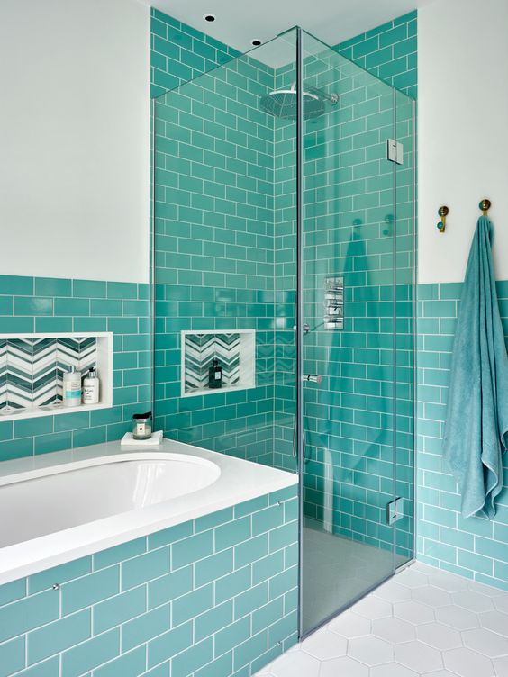 elegant turquoise tiles covering the walls and the bathtub itself complemented with white touches