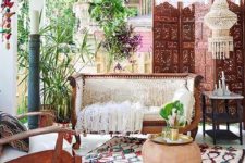 09 a chic boho porch with a wood carved bench, a chair, a printed rug, lanterns and a carved wooden screen