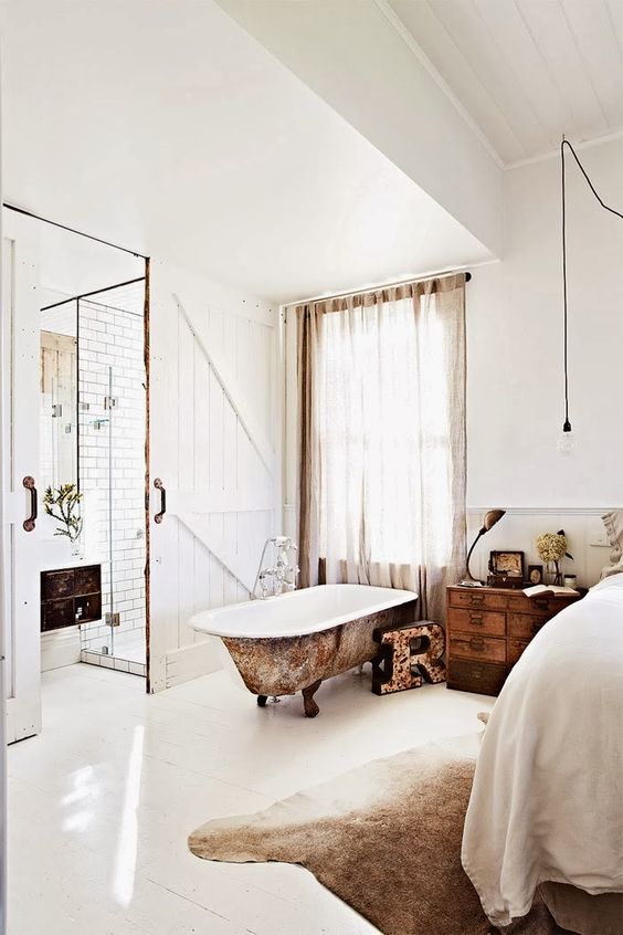 a rustic vintage bedroom with a shabby rust-touched bathtub for a vintage feel
