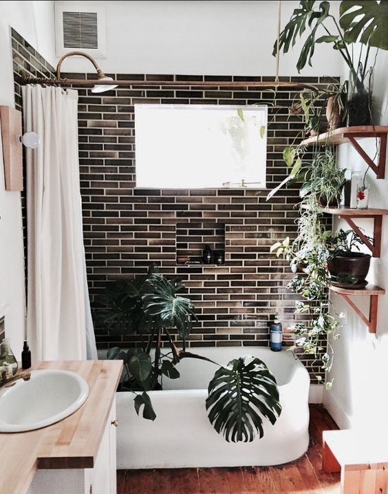 dark tiles, much potted greenery and plants, wooden touches and a creamy shower curtain