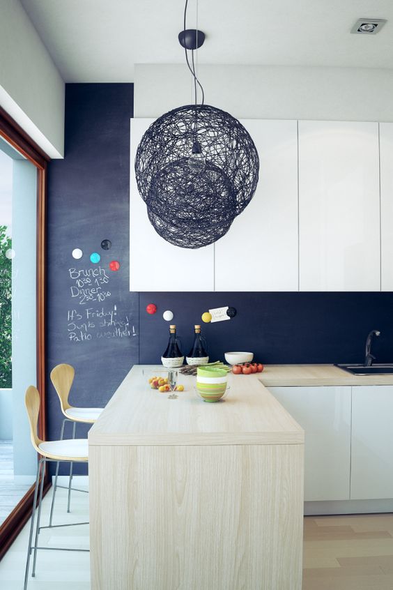 a modern white kitchen with a chalkboard backsplash and light-colored wood that make it more special