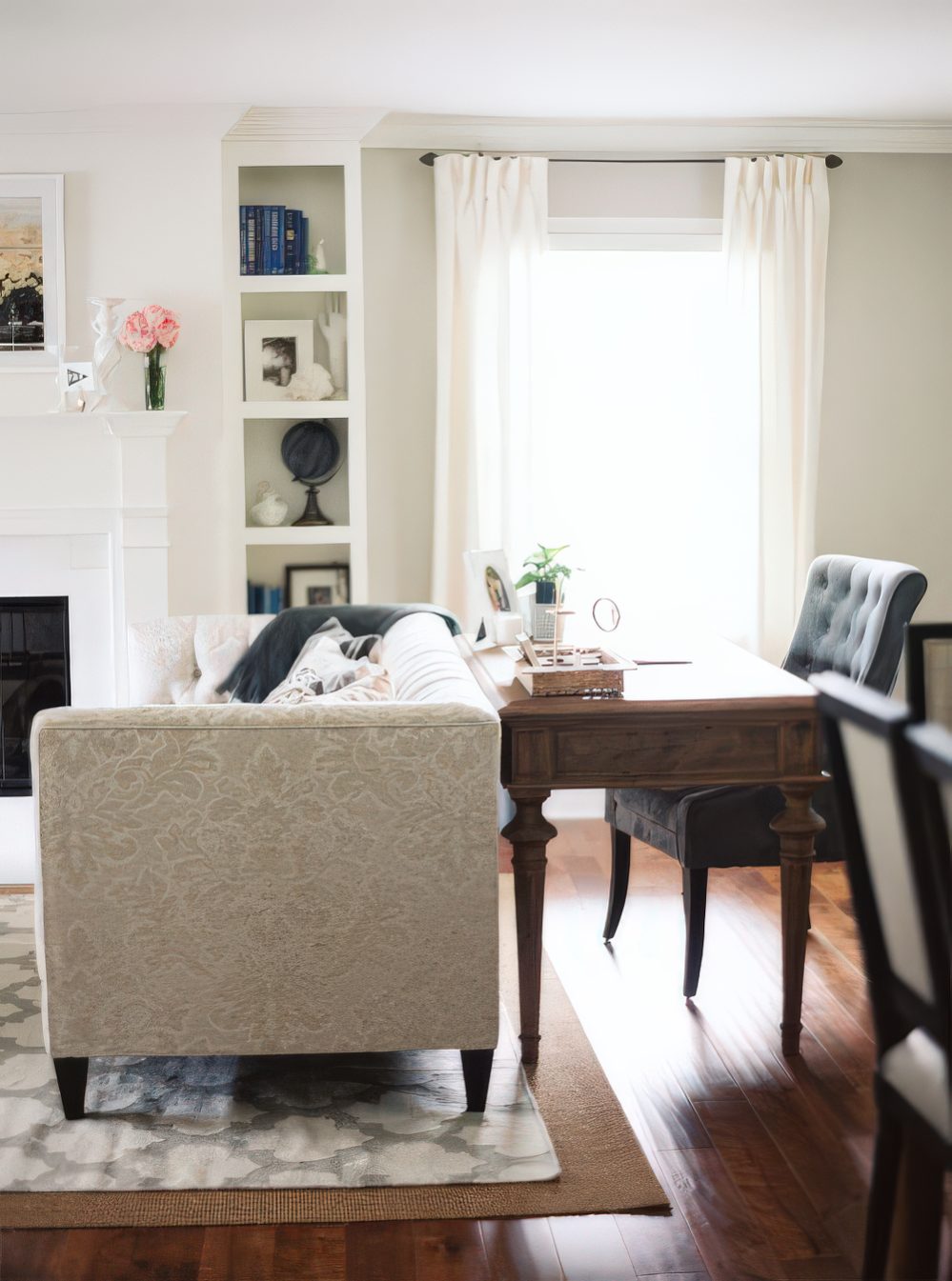 a vintage wooden desk and upholstered chair stand out from the neutral living room, so you separate the zone with color