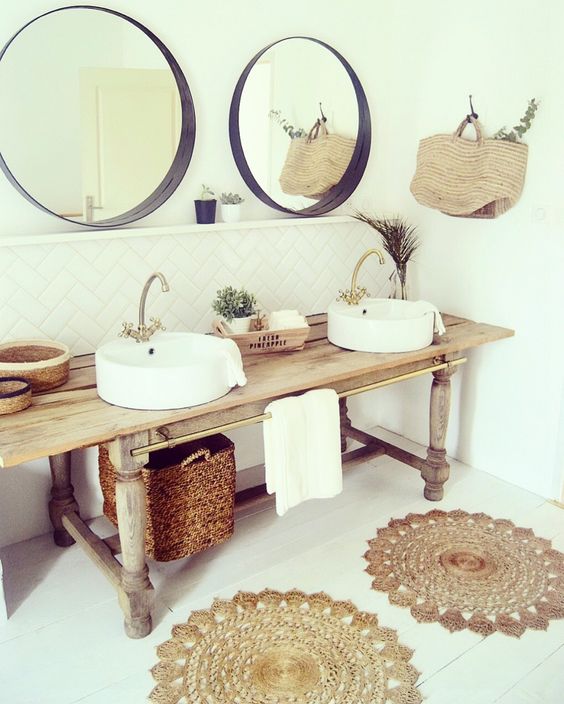 a wooden console, baskets, jute rugs and round mirrors to create a rustic boho feel in the bathroom