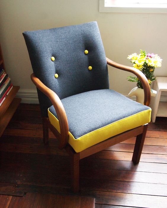 a grey chair with yellow buttons and framing of the seat for a bold and fresh look