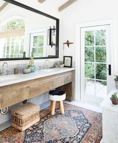 a rough wooden vanity, baskets and some potted plants plus a boho rug make the space boho chic