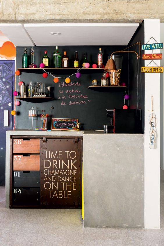 a small modern kitchen with concrete covered cabinets and chalkboard walls instead of backsplashes for a modern look
