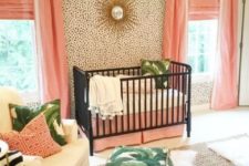 14 a glam tropical nursery with dalmatin print walls, pink textiles, black cribs and leaf print accessories