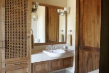14 a large wardrobe with wood lettice doors brings a relaxed and vacation feel to the bathroom