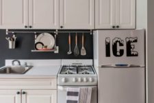 14 a traditional white kitchen with a chalkboard backsplash that features a holder for cook ware