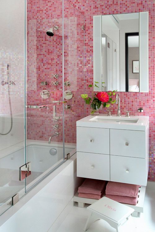 pink mosaic tiles on the walls and matching towels paired with white details for a contrasting look