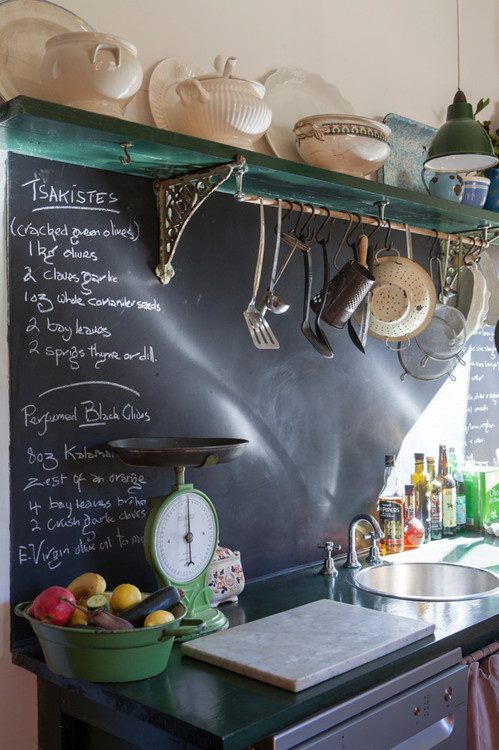 ein Vintage-Raum mit dunklen schäbigen Regalen und Arbeitsplatten und einer Tafel Backsplash