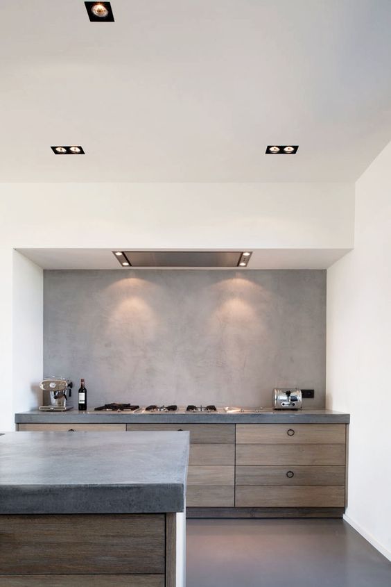 a minimalist meets industrial kitchen with a concrete backsplash and countertops plus wood for a texture