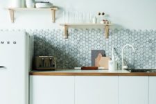 17 a minimalist white kitchen with wooden touches and a grey marble hexagon tile backsplash