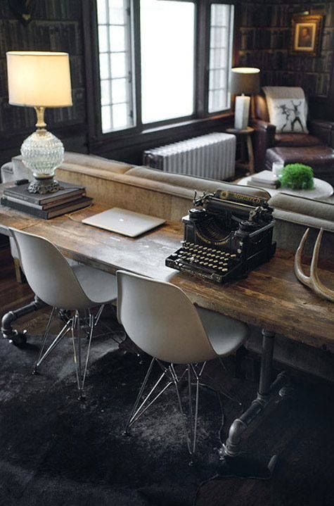 a vintage rustic desk with modern chairs placed behind the couch matches the space but accents it with the chair design