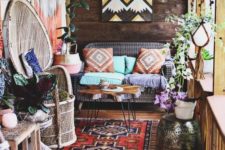19 a colorful boho porch with rattan furniture, a sofa, a hammered side table, potted plants and a colorful geo artwork