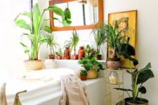 20 a boho space with potted greenery and plants, an artwork, a mirror and a wicker lampshade