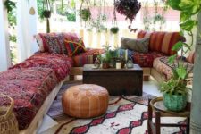 20 a colorful porch with a comfy lounge area, hanging potted greenery, lanterns, rugs and a wooden chest as a side table