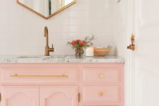 20 a light pink sink console with a marble top and gold handles and knobs are ideal for a glam bathroom look