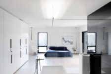 20 a minimalist spacious bedroom with a white free-standing bathtub and a sink separated only with a glass space divider