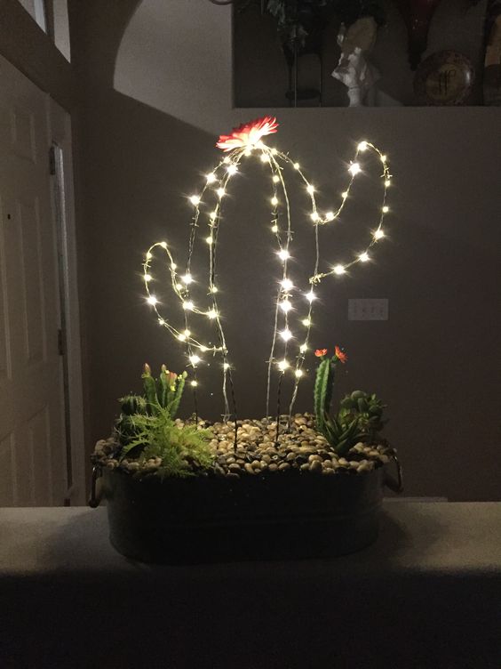 a gorgeous arrangement with cacti, succulents and a LED cactus with a flower on top