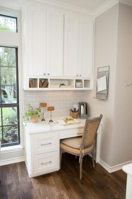 a small office space next to the window in a separate corner of the kitchen, with an upper cabinet for storage