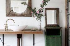 22 a green cabinet, a wood clad mirror, a wooden vanity and a a vintage faucet