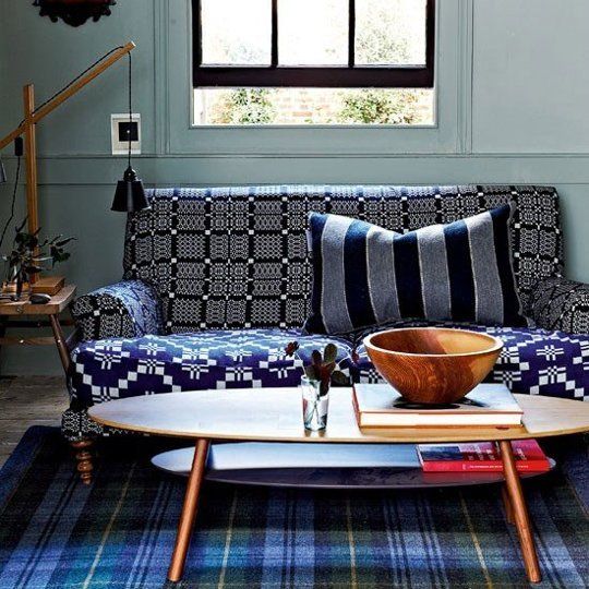 a bold sofa with a windowpane pinted back and armrests and a geometric print seat  plus a striped pillow