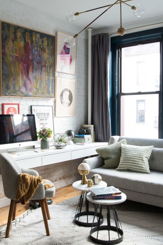 a long white sleek desk in the corner by the window for a small home office nook can be used as a console too