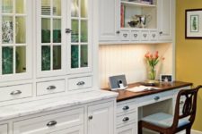 24 a traditional white kitchen with a marble countertop and a desk in the corner with a dark countertop