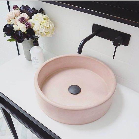 an elegant and refined round blush sink plus black touches for a stylish modenr bathroom