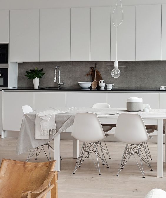 creamy cabinets with a black countertop and a grey concrete backsplash for a textural feel