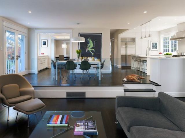 a contemporary space with a sunken living room that is divided from the kitchen and dining space this way