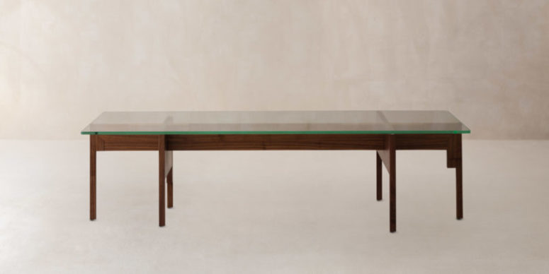 The dining table is made of dark stained wood and features a glass top
